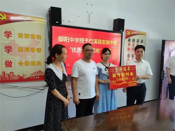 郧阳中学校长黎明现场将"优质生源基地"北大之星"奖牌授予该县实验